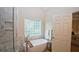 Bright bathroom features a soaking tub with modern fixtures and a glass block window for natural light at 102 Cavit Ct, Canton, GA 30114