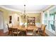 Formal dining room with elegant chandelier, wainscoting, and large windows offering ample natural light at 102 Cavit Ct, Canton, GA 30114