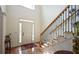 Open foyer with hardwood floors, staircase with iron spindles, and front door with transom window at 102 Cavit Ct, Canton, GA 30114