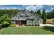 Beautiful two-story home featuring a well-manicured lawn, complemented by mature trees and a detached garage at 102 Cavit Ct, Canton, GA 30114