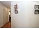 Hallway with hardwood floors and white walls decorated with framed pictures at 102 Cavit Ct, Canton, GA 30114