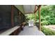 Covered outdoor deck featuring a built-in grill and bar for outdoor cooking and entertaining with view of lush landscaping at 102 Cavit Ct, Canton, GA 30114