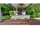 Spacious covered outdoor kitchen area with stainless appliances, ceiling fans, and a rustic wood table at 102 Cavit Ct, Canton, GA 30114