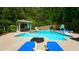 Large private backyard with a beautiful in-ground pool, water slide, hot tub, and lounge seating at 102 Cavit Ct, Canton, GA 30114