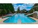 Sparkling blue pool with diving board, slide, lounge chairs, mature trees, and lovely landscaping at 102 Cavit Ct, Canton, GA 30114