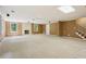 Spacious carpeted basement with a brick fireplace and multiple windows at 10660 Dunoon Dr, Alpharetta, GA 30022