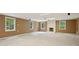 Expansive carpeted basement with fireplace, natural light from windows and recessed lighting at 10660 Dunoon Dr, Alpharetta, GA 30022