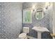Powder room with modern wallpaper, pedestal sink, and brushed nickel lighting fixtures at 10660 Dunoon Dr, Alpharetta, GA 30022