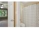 This full bathroom is attached to the bedroom and features a toilet and a shower with a shower curtain at 10660 Dunoon Dr, Alpharetta, GA 30022