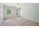 This light blue bedroom boasts neutral carpeting, two large windows, ceiling fan and a double door closet at 10660 Dunoon Dr, Alpharetta, GA 30022