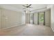 A large bedroom with a tray ceiling, ceiling fan, and windows overlooking the property's landscape at 10660 Dunoon Dr, Alpharetta, GA 30022