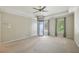 A large bedroom with a tray ceiling, ceiling fan, windows overlooking the property, and an elevator at 10660 Dunoon Dr, Alpharetta, GA 30022