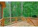 Wooden deck surrounded by lush green trees at 10660 Dunoon Dr, Alpharetta, GA 30022