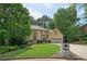 Beautiful home boasts a lush green lawn, mature trees, and a stately stone mailbox at 10660 Dunoon Dr, Alpharetta, GA 30022