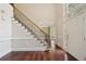 Staircase with wrought iron railing, hardwood floors, and front door with sidelight windows at 10660 Dunoon Dr, Alpharetta, GA 30022
