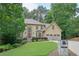 Charming two-story home with three-car garage, mature trees, and landscaped front yard at 10660 Dunoon Dr, Alpharetta, GA 30022