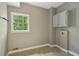 A simple laundry room featuring tile floors, a window, and some wall cabinets at 10660 Dunoon Dr, Alpharetta, GA 30022