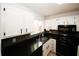 Updated kitchen with sleek black countertops, white cabinets, and modern appliances at 1199 Ashborough Se Dr # K, Marietta, GA 30067