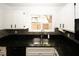 Well-lit kitchen features black granite counters, stainless steel sink, and mosaic backsplash at 1199 Ashborough Se Dr # K, Marietta, GA 30067