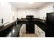 Modern kitchen featuring black appliances, granite countertops, and bright white cabinetry at 1199 Ashborough Se Dr # K, Marietta, GA 30067