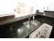 Kitchen sink area with granite countertops, stainless steel sink, and white cabinets at 1199 Ashborough Se Dr # K, Marietta, GA 30067