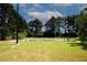 Community tennis court with well-maintained green space and tall trees adding shade to the tennis play area at 1199 Ashborough Se Dr # K, Marietta, GA 30067
