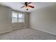 Neutral bedroom with window, ceiling fan, and plush gray carpeting throughout the entire living space at 1391 Sutters Dr, Lawrenceville, GA 30045