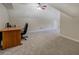 Spacious carpeted bedroom features a wooden desk, ceiling fan, and an attached bathroom at 1391 Sutters Dr, Lawrenceville, GA 30045