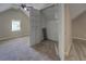 Carpeted bedroom leading to attic storage with wire shelving, ceiling fan and window at 1391 Sutters Dr, Lawrenceville, GA 30045