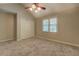 Spacious carpeted bedroom features a ceiling fan, window and a large closet with doors at 1391 Sutters Dr, Lawrenceville, GA 30045