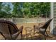 Relaxing deck features wicker chairs, side table, and a peaceful view at 1391 Sutters Dr, Lawrenceville, GA 30045