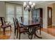 Formal dining room featuring hardwood floors, a chandelier, and a dark wood table with seating for six at 1391 Sutters Dr, Lawrenceville, GA 30045