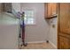 A well-lit laundry room equipped with storage cabinets, drying rack, and a view to the backyard at 1391 Sutters Dr, Lawrenceville, GA 30045