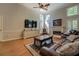 Bright living room with hardwood floors, fireplace, large windows, and a comfortable leather sofa at 1391 Sutters Dr, Lawrenceville, GA 30045