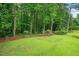 Spacious backyard with a lush green lawn, mature trees, and a wooded area providing privacy and natural beauty at 9060 Par Dr, Douglasville, GA 30134