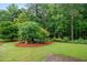 Lush backyard with mature trees, green lawn, and landscaped garden beds, perfect for outdoor enjoyment at 9060 Par Dr, Douglasville, GA 30134