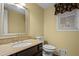 Cozy bathroom featuring a toilet and a granite countertop vanity with a mirror at 9060 Par Dr, Douglasville, GA 30134