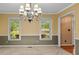 Formal dining room featuring neutral carpet, large chandelier, and natural light from large windows showcasing backyard views at 9060 Par Dr, Douglasville, GA 30134