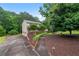 Two-story home with a long driveway, mature trees, and lush landscaping, offering privacy and curb appeal at 9060 Par Dr, Douglasville, GA 30134