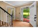 Inviting foyer with hardwood floors, a view of the staircase, and a glimpse of the outdoor scenery through the open door at 9060 Par Dr, Douglasville, GA 30134