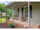 Inviting front porch with cozy seating, brick accents, and views of the landscaped front yard at 9060 Par Dr, Douglasville, GA 30134