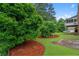 Beautiful landscaping with well-manicured lawn and mature trees for privacy, and an elevated screened porch in background at 9060 Par Dr, Douglasville, GA 30134