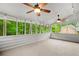 Enclosed sunroom with ample natural light, carpeted flooring, ceiling fans, and views of the lush backyard at 9060 Par Dr, Douglasville, GA 30134