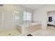 Bathroom featuring a shower with glass door and a soaking tub under a window with blinds at 3173 Rockbridge Rd, Avondale Estates, GA 30002