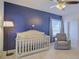 This lovely Bedroom features a crib, chair, and a blue accent wall at 3173 Rockbridge Rd, Avondale Estates, GA 30002