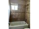 Tiled bathroom showcasing a shower over tub and neutral colored tile at 3298 Abbeywood Dr, Decatur, GA 30034