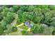 Bird's eye view of the home highlighting mature trees, a pool, and a driveway at 5025 Oak Bluff Ct, Atlanta, GA 30350