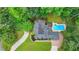 Aerial view of the home with mature trees, a pool, and a driveway at 5025 Oak Bluff Ct, Atlanta, GA 30350