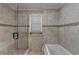 Bright bathroom showcasing tiled walls, shower with glass door, and a soaking tub at 5025 Oak Bluff Ct, Atlanta, GA 30350