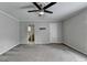 Large bedroom with ceiling fan, neutral walls, and doorways to the hallway and bathroom at 5025 Oak Bluff Ct, Atlanta, GA 30350